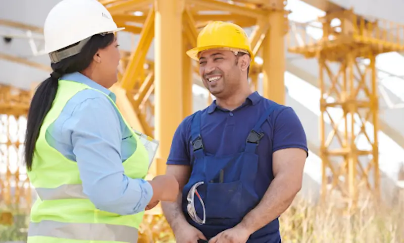 construction worker smiling and talking to supervisor